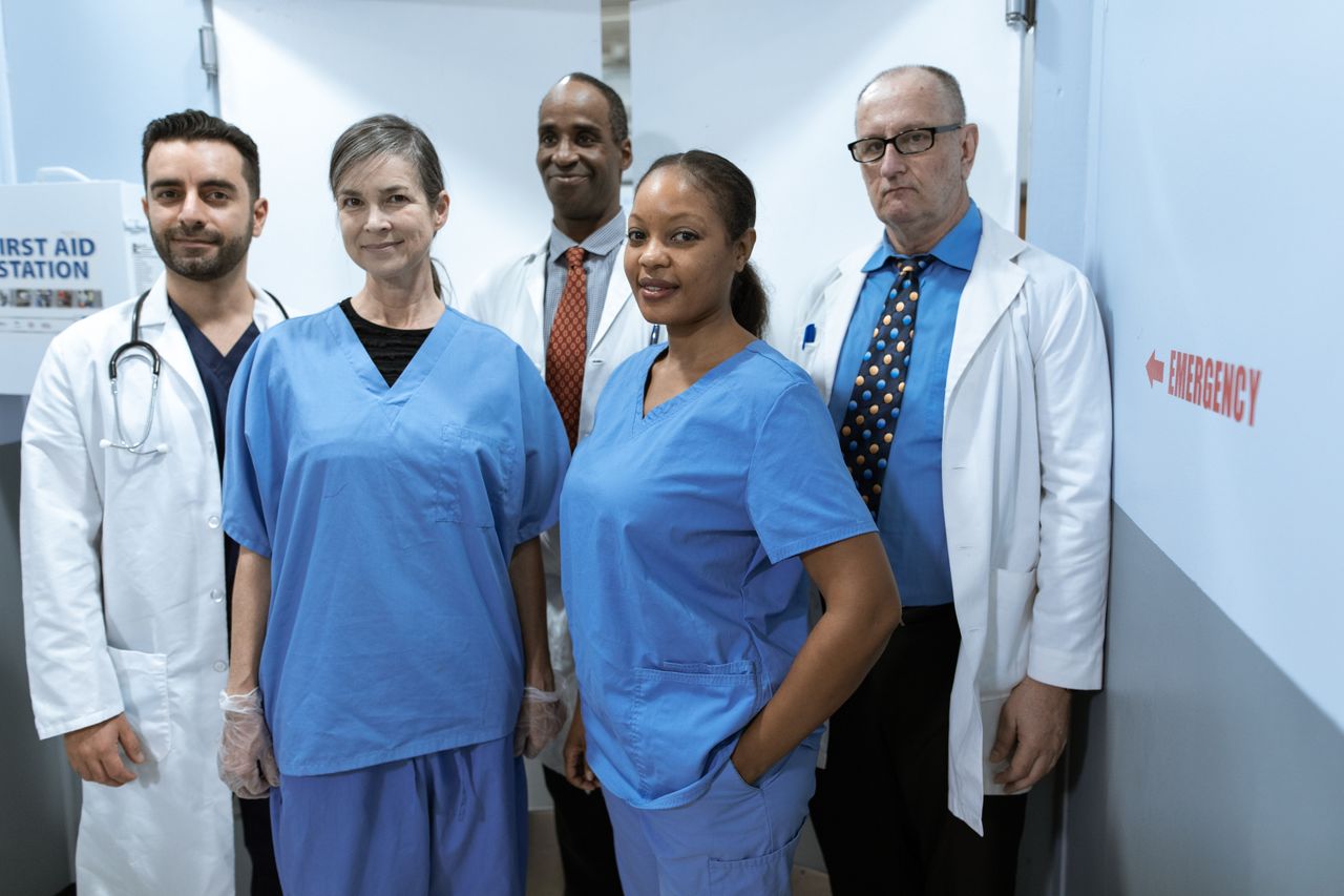 Home A diverse group of healthcare professionals in hospital uniforms, showcasing teamwork and diversity.
