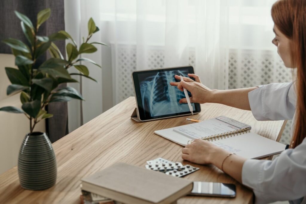 The Art of Drawing Readers In: Your attractive post title goes here Healthcare professional examines X-ray image on tablet at desk with medical notes.